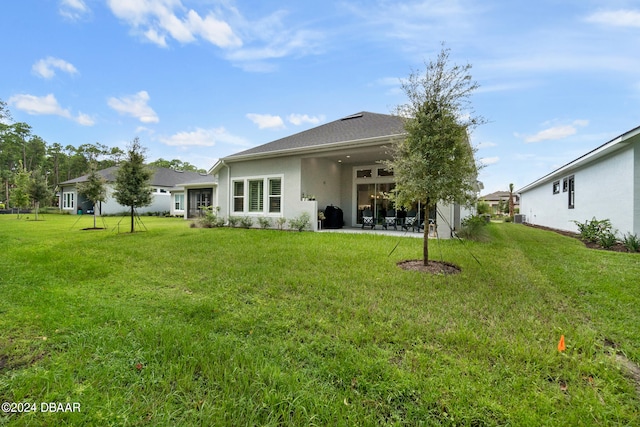 back of property with a yard and a patio area