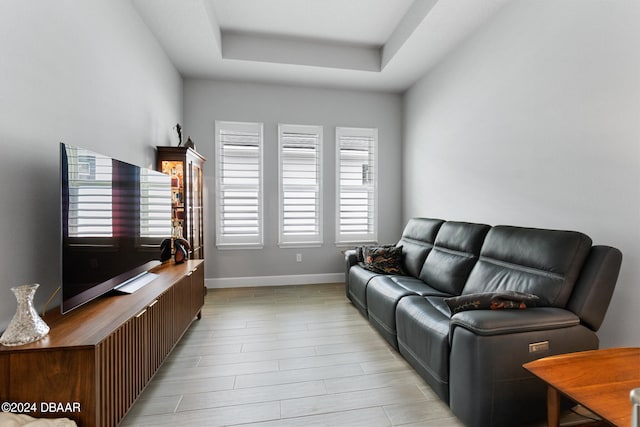 living room with light hardwood / wood-style flooring and a tray ceiling