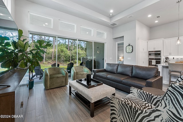 living room with hardwood / wood-style floors and a high ceiling