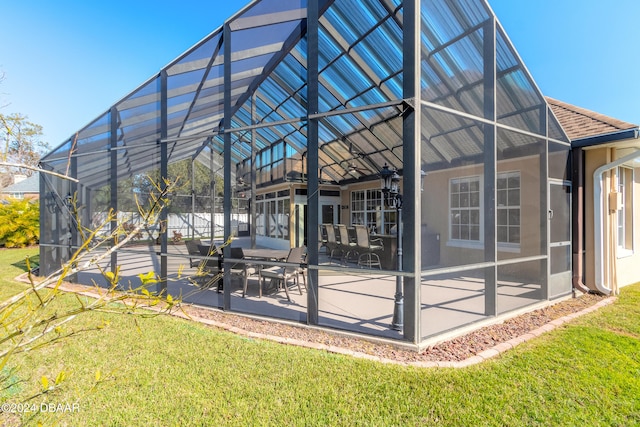 rear view of house with a patio, a yard, and glass enclosure