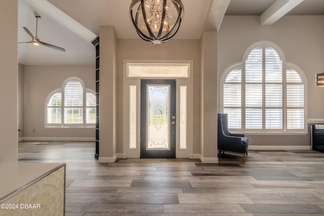 foyer featuring beam ceiling, hardwood / wood-style flooring, and ceiling fan with notable chandelier