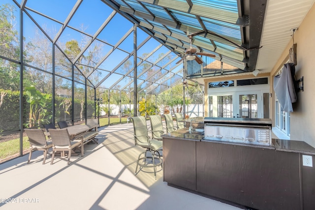 view of patio / terrace with french doors, exterior bar, an outdoor kitchen, glass enclosure, and ceiling fan