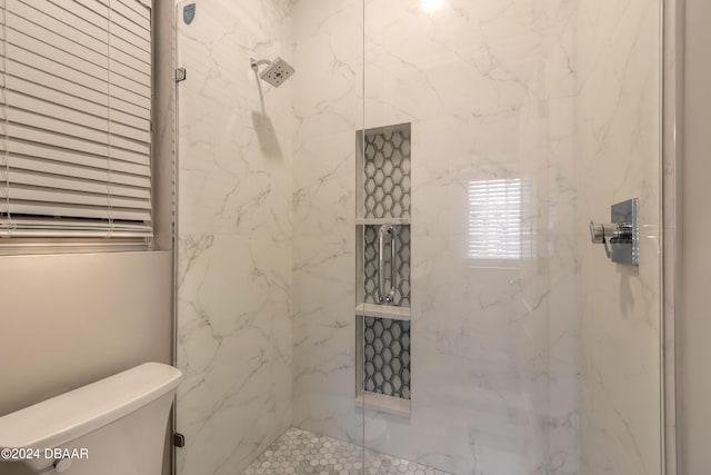 bathroom with toilet and a shower with shower door