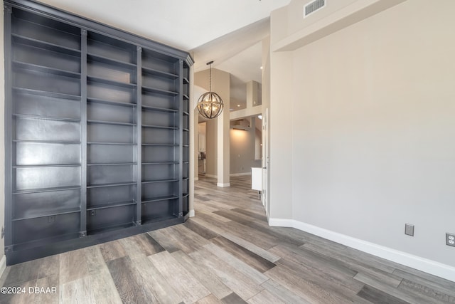 spare room featuring wood-type flooring and lofted ceiling