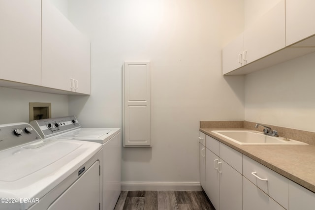 laundry area featuring washer and clothes dryer, dark wood-type flooring, cabinets, and sink