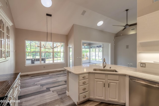 kitchen with appliances with stainless steel finishes, sink, white cabinets, lofted ceiling, and light hardwood / wood-style flooring