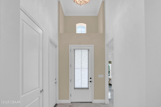 464 Tropics Ave, Daytona Beach, FL 32124 - foyer entrance with light marble finish flooring, ornamental molding, a high ceiling, a chandelier, and baseboards