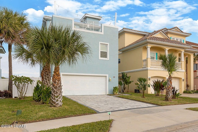 mediterranean / spanish-style home featuring a balcony, a garage, and a front lawn