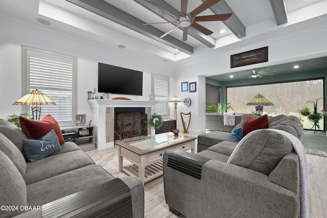 living room with beamed ceiling, light hardwood / wood-style floors, and ceiling fan