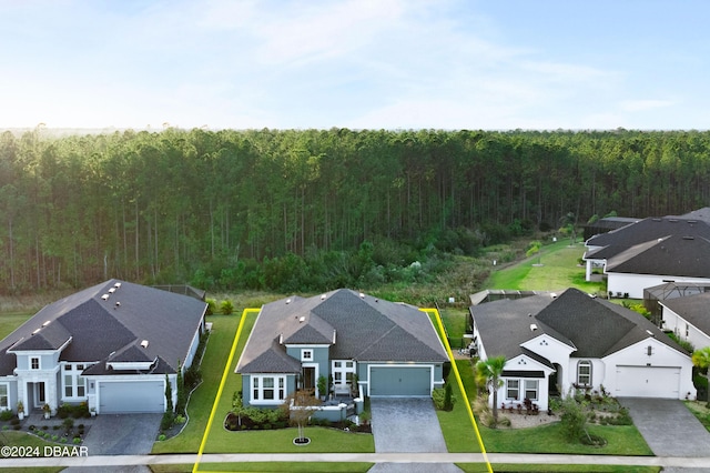 drone / aerial view with a residential view and a wooded view