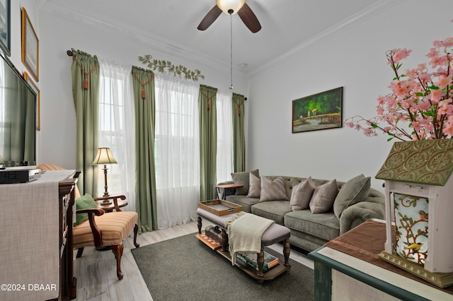 living room featuring crown molding, ceiling fan, and light wood-type flooring