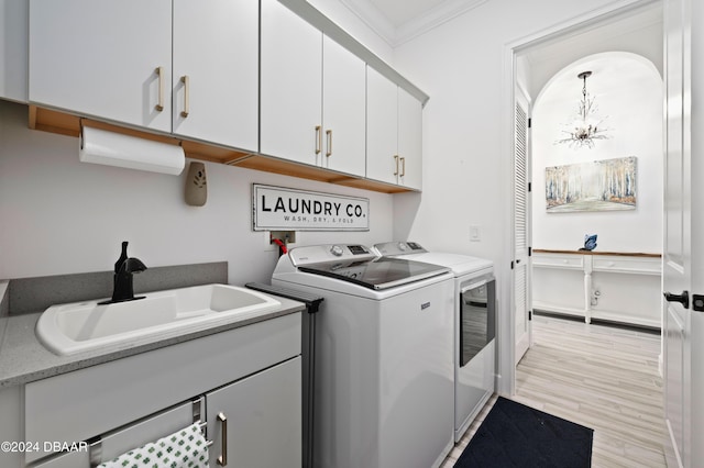 clothes washing area featuring cabinets, sink, independent washer and dryer, ornamental molding, and light hardwood / wood-style floors