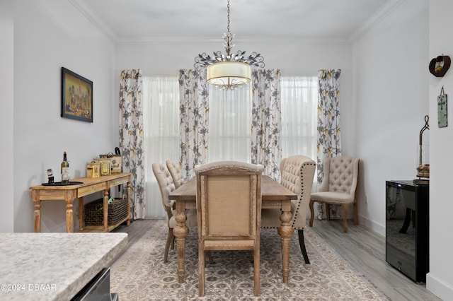 dining area with ornamental molding and light hardwood / wood-style flooring