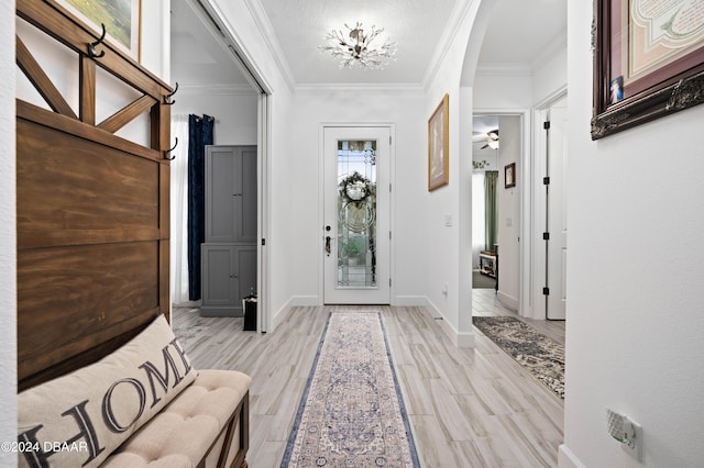 foyer featuring ceiling fan, ornamental molding, and light hardwood / wood-style flooring