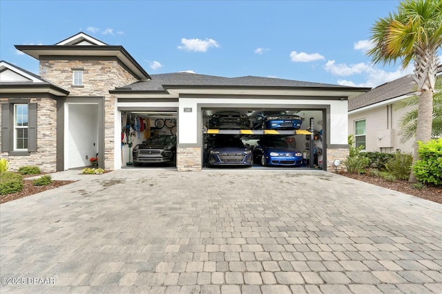 prairie-style home featuring stone siding, stucco siding, decorative driveway, and a garage