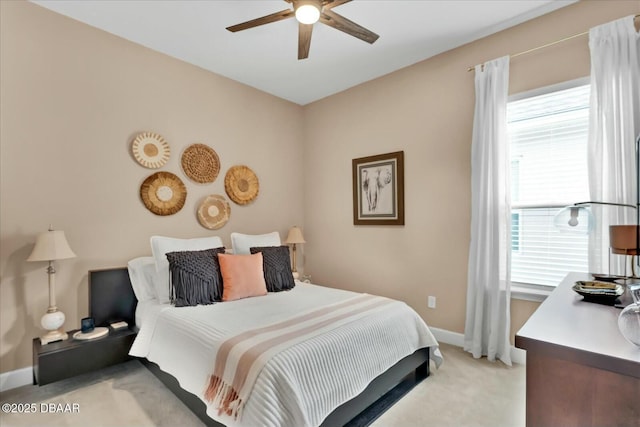 bedroom with ceiling fan, baseboards, and light carpet