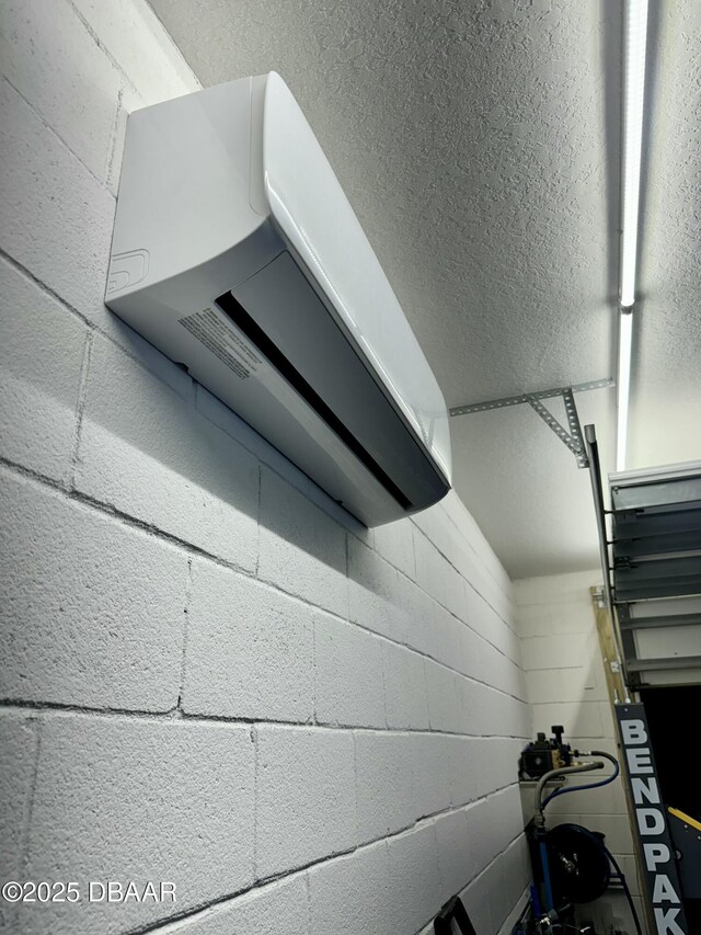 540 Mosaic Blvd, Daytona Beach, FL 32124 - garage view of a wall mounted AC, a textured ceiling, and concrete block wall