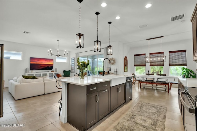 kitchen featuring visible vents, a sink, open floor plan, light countertops, and stainless steel electric range oven