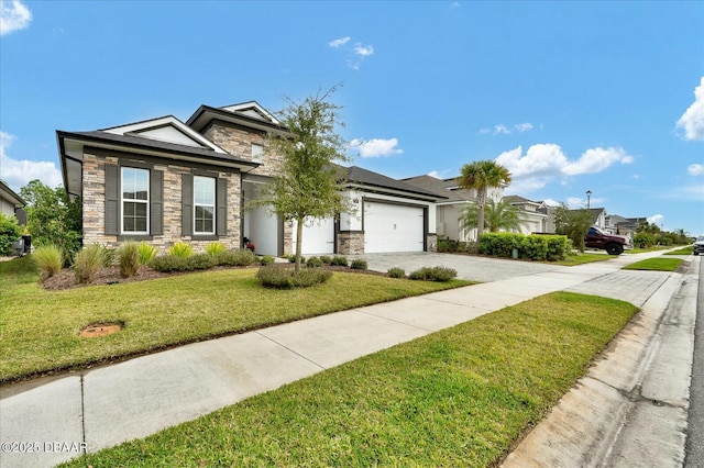 view of front of property with stone siding, an attached garage, driveway, and a front yard