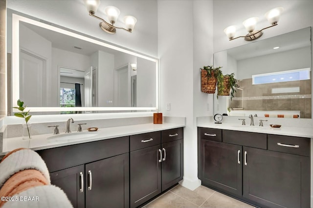 bathroom featuring tile patterned floors, a healthy amount of sunlight, two vanities, and a sink