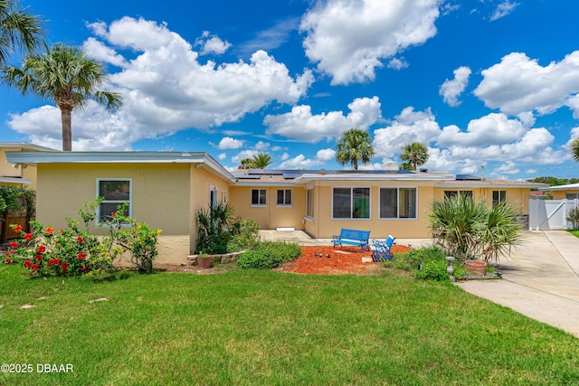 1104 Jacaranda Ave, Daytona Beach, FL 32118 - view of front of house with a gate, solar panels, stucco siding, and concrete driveway