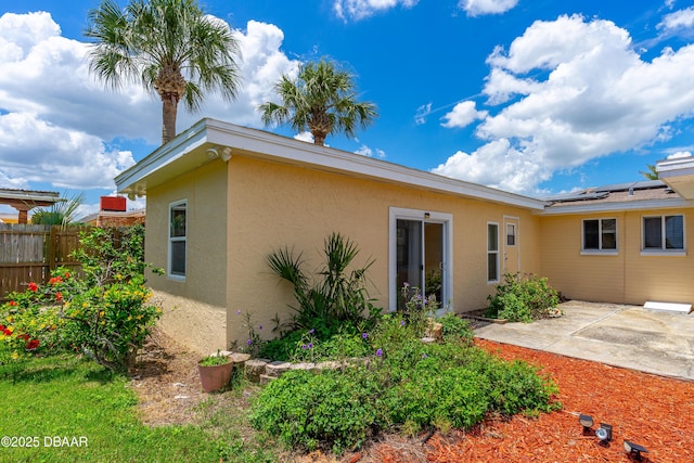 1104 Jacaranda Ave, Daytona Beach, FL 32118 - back of house featuring stucco siding, a patio, and solar panels