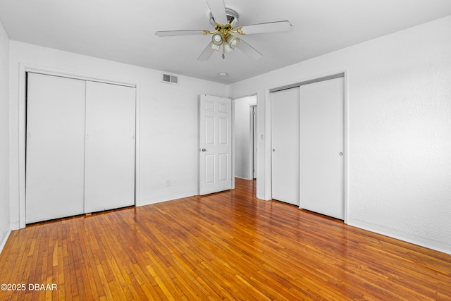 1104 Jacaranda Ave, Daytona Beach, FL 32118 - unfurnished bedroom with multiple closets, hardwood / wood-style floors, and a ceiling fan