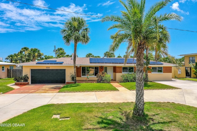 1104 Jacaranda Ave, Daytona Beach, FL 32118 - view of front of house with concrete driveway, a garage, brick siding, and roof mounted solar panels