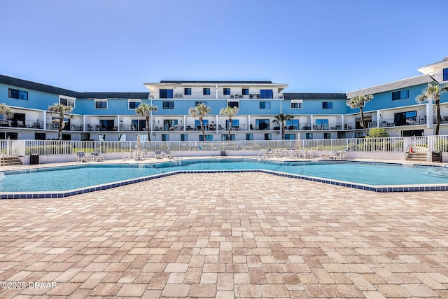 community pool featuring fence and a patio