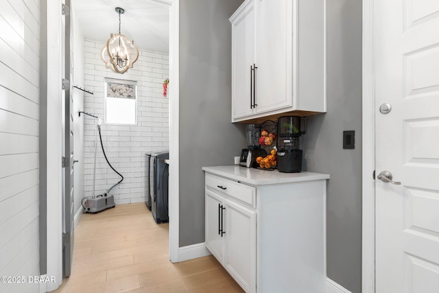 75 Trailmark Ct, Ormond Beach, FL 32174 - laundry room featuring a chandelier, light wood finished floors, and washer / dryer