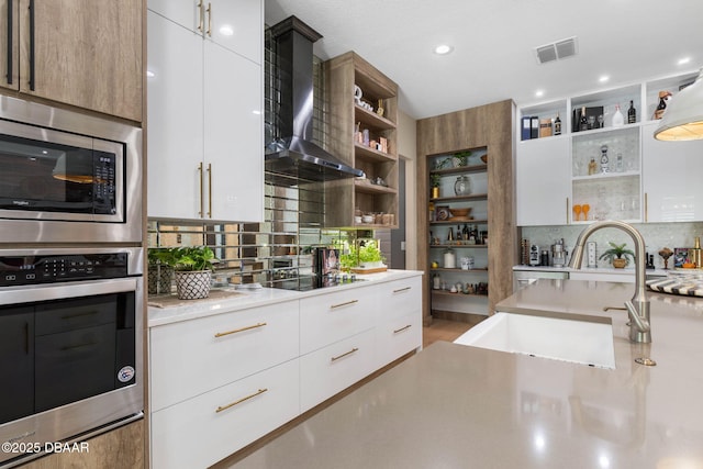 75 Trailmark Ct, Ormond Beach, FL 32174 - kitchen with open shelves, modern cabinets, wall chimney range hood, appliances with stainless steel finishes, and light countertops
