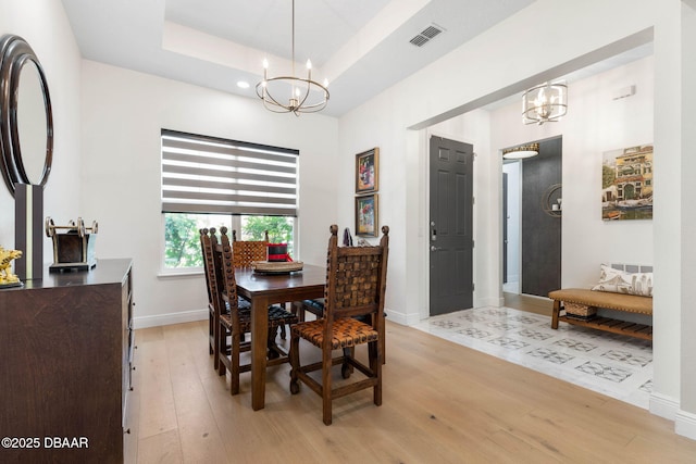 75 Trailmark Ct, Ormond Beach, FL 32174 - dining room with a chandelier, light wood-style flooring, and a tray ceiling