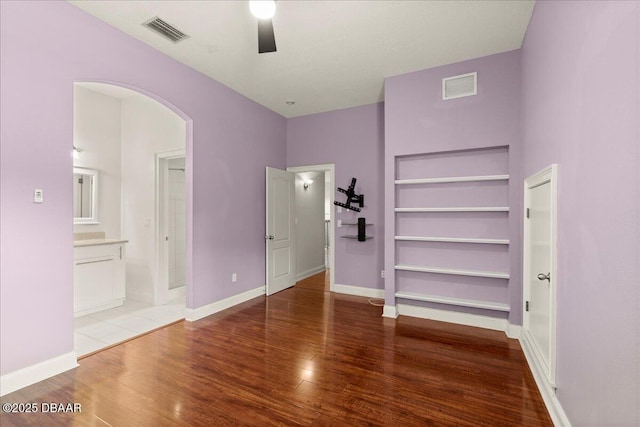 36 Allenwood Look, Ormond Beach, FL 32174 - unfurnished bedroom with arched walkways, wood finished floors, ensuite bathroom, and a ceiling fan