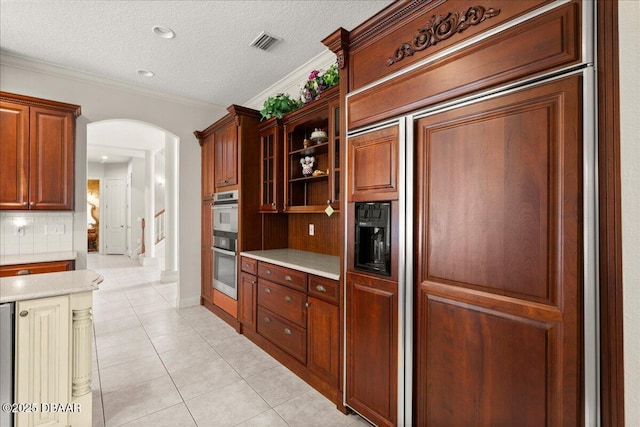 36 Allenwood Look, Ormond Beach, FL 32174 - kitchen with arched walkways, paneled built in refrigerator, light tile patterned floors, ornamental molding, and a textured ceiling