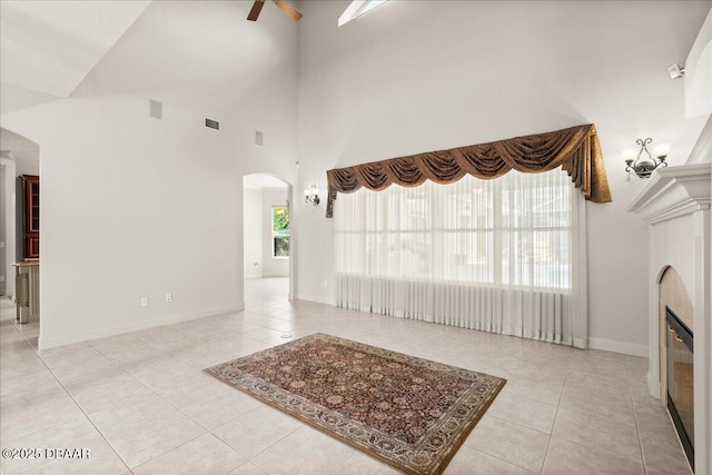 36 Allenwood Look, Ormond Beach, FL 32174 - unfurnished living room with arched walkways, light tile patterned flooring, a ceiling fan, and a high ceiling