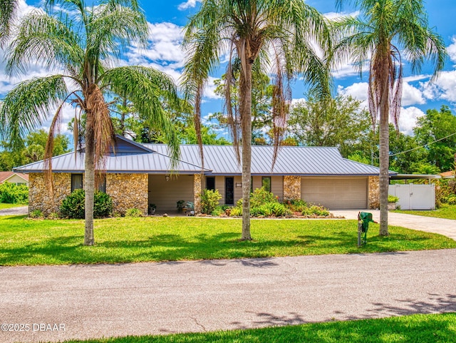108 Dee St, New Smyrna Beach, FL 32168 - mid-century modern home featuring stone siding, a standing seam roof, concrete driveway, an attached garage, and a front lawn