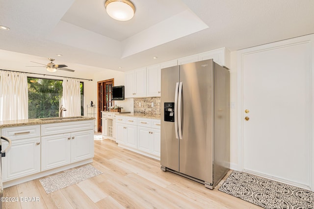 kitchen featuring stainless steel refrigerator with ice dispenser, white cabinetry, a raised ceiling, and sink