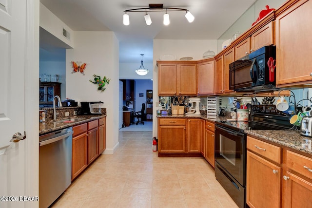 kitchen with sink, dark stone counters, hanging light fixtures, light tile patterned floors, and black appliances