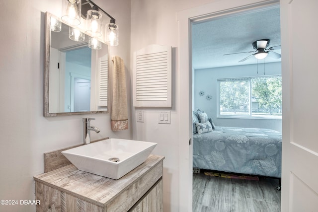 bathroom with ceiling fan, vanity, a textured ceiling, and hardwood / wood-style flooring