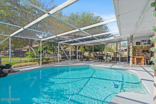 14 Woodlake Dr, Port Orange, FL 32129 - outdoor pool with a patio area, a fenced backyard, and a lanai