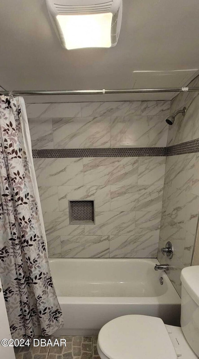 bathroom with shower / tub combo with curtain and toilet