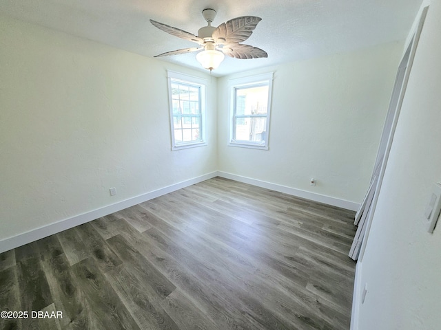 spare room featuring wood finished floors, baseboards, and a ceiling fan