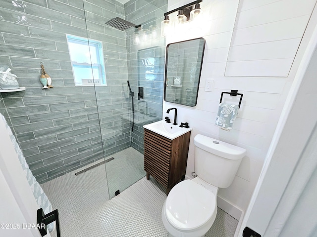 bathroom with a shower stall, vanity, toilet, and tile patterned floors