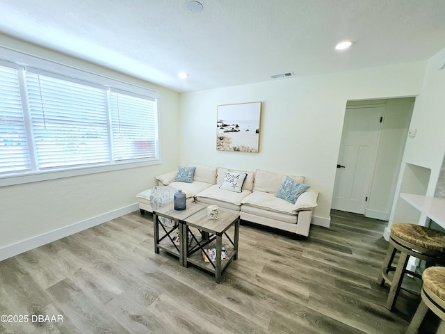 living area featuring wood finished floors, baseboards, and recessed lighting