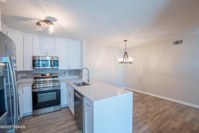 15 Misners Trl, Ormond Beach, FL 32174 - kitchen with stainless steel appliances, a sink, a peninsula, light wood-style flooring, and light countertops