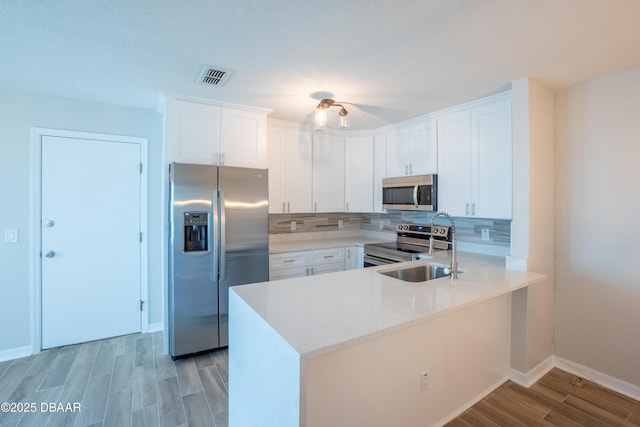 15 Misners Trl, Ormond Beach, FL 32174 - kitchen with appliances with stainless steel finishes, a sink, a peninsula, tasteful backsplash, and baseboards