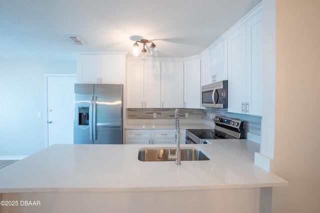 15 Misners Trl, Ormond Beach, FL 32174 - kitchen featuring stainless steel appliances, a sink, backsplash, light stone counters, and white cabinets