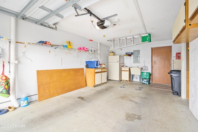 garage with electric panel, sink, white fridge, and a garage door opener