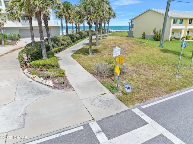 view of property's community with a water view and a lawn