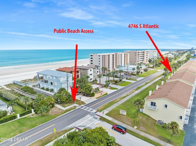 bird's eye view featuring a water view and a beach view